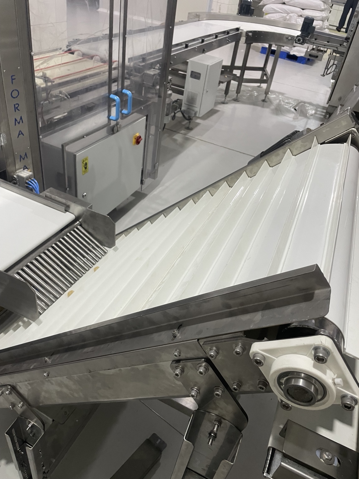 Transverse belt cleats and production-line transfer point